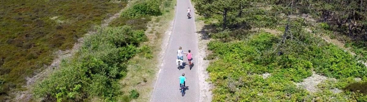 Radfahrer auf einer Straße durch die Dünen